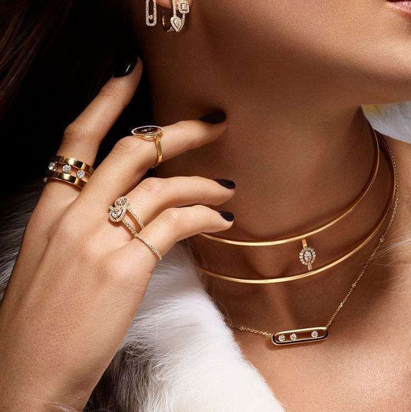 Model wearing gold rings and necklace